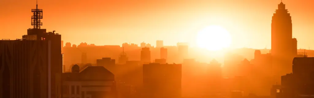 Intense sun over a city skyline during a heatwave