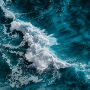 Aerial image of a turbulent sea, demonstrating the power of crashing waves in the context of harnessing wave energy.