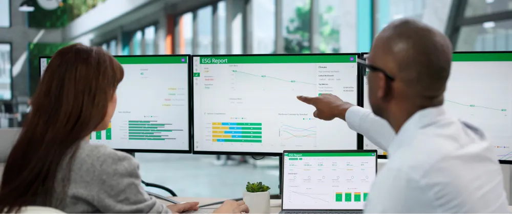 Business professionals reviewing energy and carbon compliance data in an office meeting