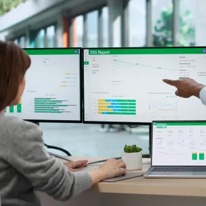 Business professionals reviewing energy and carbon compliance data in an office meeting